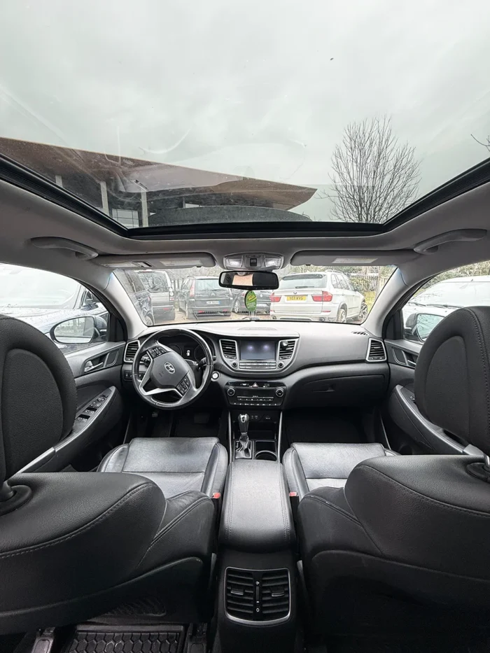 Interior of Hyundai Tucson 2017 showing leather seats, dashboard and panoramic glass roof