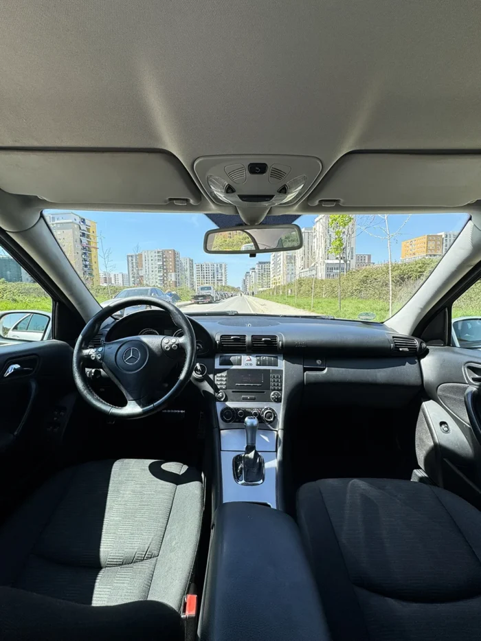 Interior of Mercedes C-Class 2007 1.8 petrol automatic sedan showing front seats, steering wheel and centre console