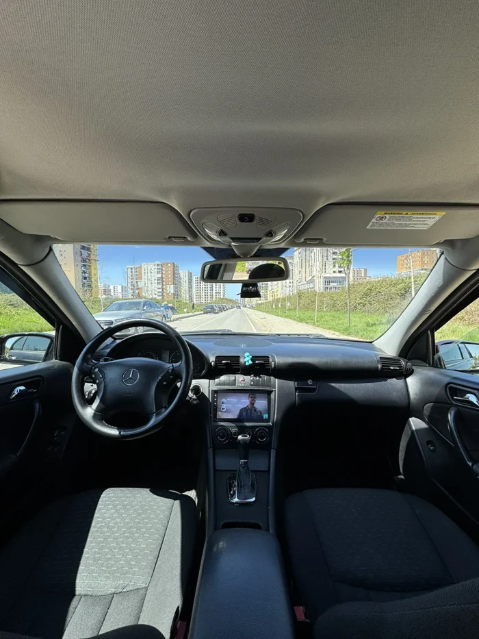 Interior of Mercedes C-Class 2007 C220 automatic sedan showing front seats, steering wheel and multimedia screen