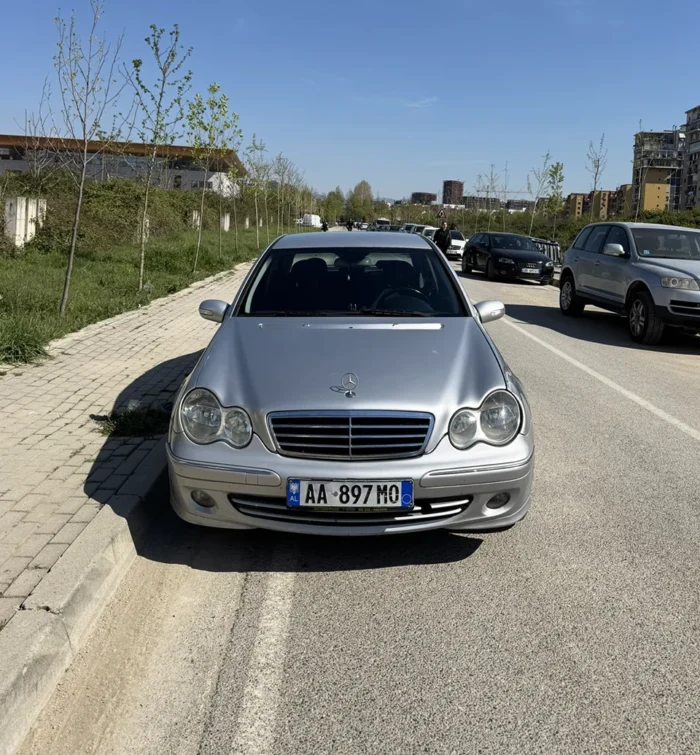 Front view of silver Mercedes C-Class 2007 2.2 CDI automatic executive sedan on a residential street in Albania