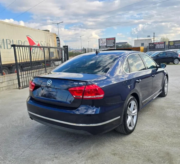 Rear three-quarter view of dark blue VW Passat SEL 2013 2.0 TDI diesel automatic rental car with sunroof parked in Albania