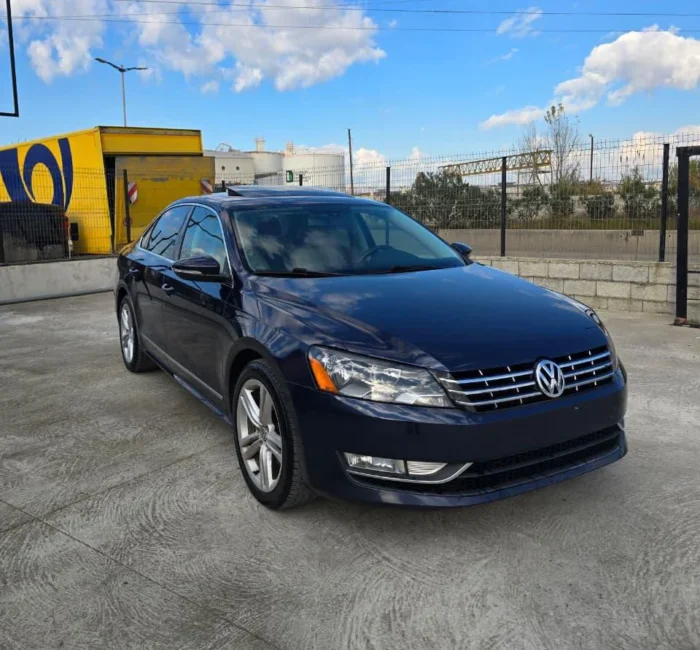 Front three-quarter view of dark blue VW Passat SEL 2013 diesel automatic rental car with panoramic sunroof parked in Tirana