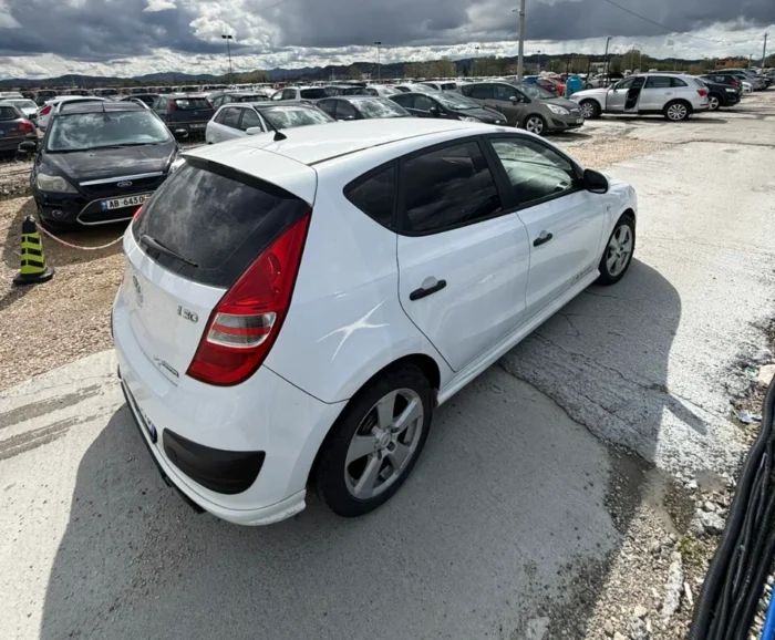 White Hyundai i30 2010 1.6 diesel manual hatchback rental car parked near Tirana International Airport Rinas with air‑conditioned interior