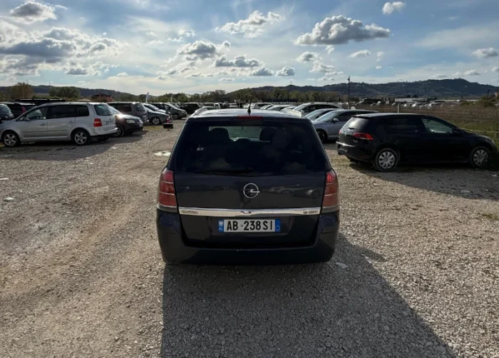 Dark Opel Zafira 2008 2.0 diesel manual 7 seater MPV rental car parked near Tirana International Airport Rinas with flexible three row seating