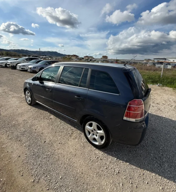 Dark Opel Zafira 2008 2.0 diesel manual 7 seater MPV rental car parked near Tirana International Airport Rinas with flexible three row seating
