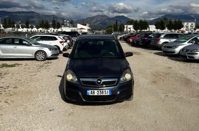 Dark Opel Zafira 2008 2.0 diesel manual 7 seater MPV rental car parked near Tirana International Airport Rinas with flexible three row seating