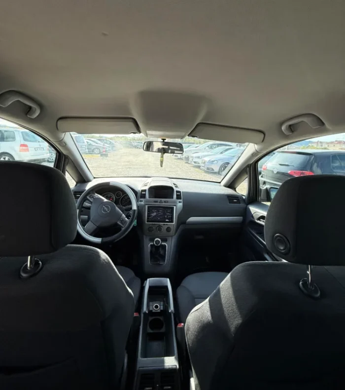Dark Opel Zafira 2008 2.0 diesel manual 7 seater MPV rental car parked near Tirana International Airport Rinas with flexible three row seating