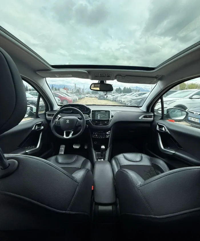 White Peugeot 208 2016 1.6 diesel automatic hatchback with full panoramic glass roof parked on the rental car lot near Tirana International Airport Rinas
