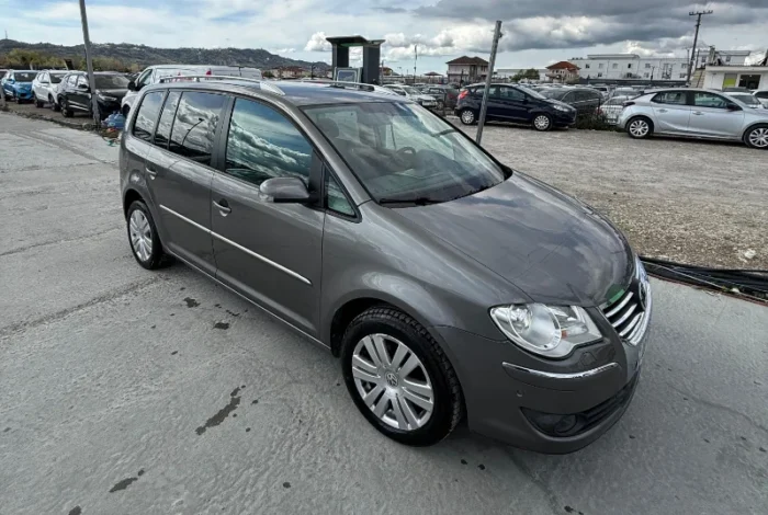 Grey Volkswagen Touran 2008 1.6 petrol automatic compact MPV rental car parked near Tirana International Airport Rinas with leather interior