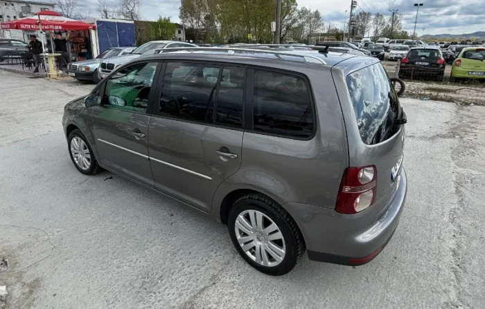 Grey Volkswagen Touran 2008 1.6 petrol automatic compact MPV rental car parked near Tirana International Airport Rinas with leather interior