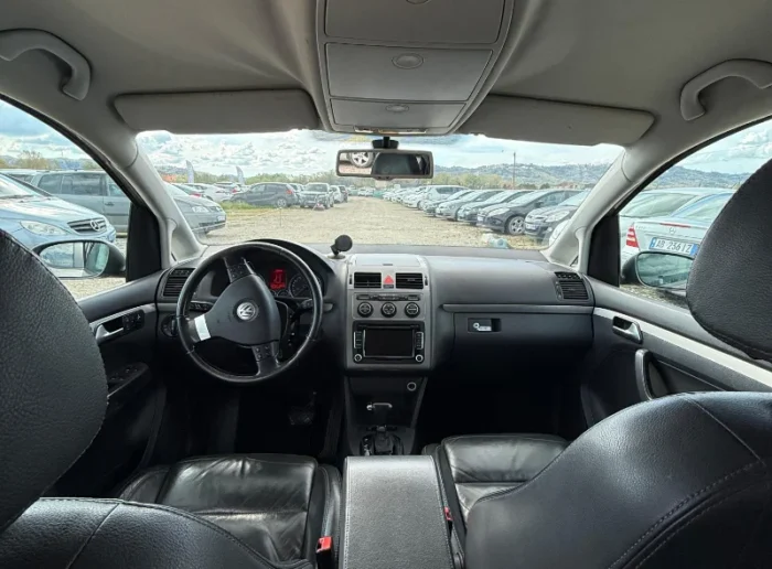 Grey Volkswagen Touran 2008 1.6 petrol automatic compact MPV rental car parked near Tirana International Airport Rinas with leather interior