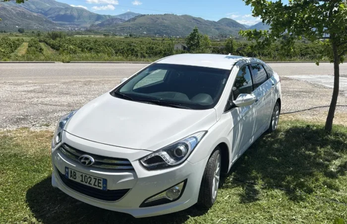 White Hyundai i40 2012 1.7 diesel automatic mid‑size sedan parked in the Albanian countryside, available for rent from Tirana and Tirana Airport Rinas