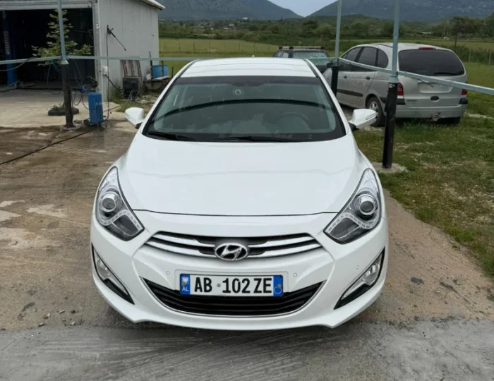 White Hyundai i40 2012 1.7 diesel automatic mid‑size sedan parked in the Albanian countryside, available for rent from Tirana and Tirana Airport Rinas