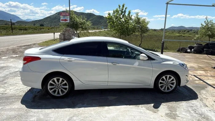 White Hyundai i40 2012 1.7 diesel automatic mid‑size sedan parked in the Albanian countryside, available for rent from Tirana and Tirana Airport Rinas