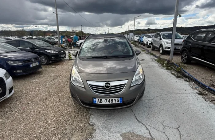 Grey Opel Meriva 2012 2.0 diesel manual compact MPV with panoramic sunroof and dark interior parked near Tirana International Airport Rinas