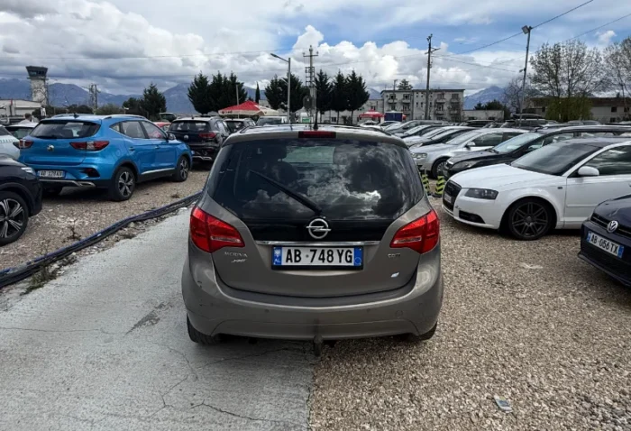 Grey Opel Meriva 2012 2.0 diesel manual compact MPV with panoramic sunroof and dark interior parked near Tirana International Airport Rinas