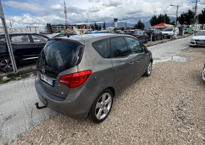 Grey Opel Meriva 2012 2.0 diesel manual compact MPV with panoramic sunroof and dark interior parked near Tirana International Airport Rinas