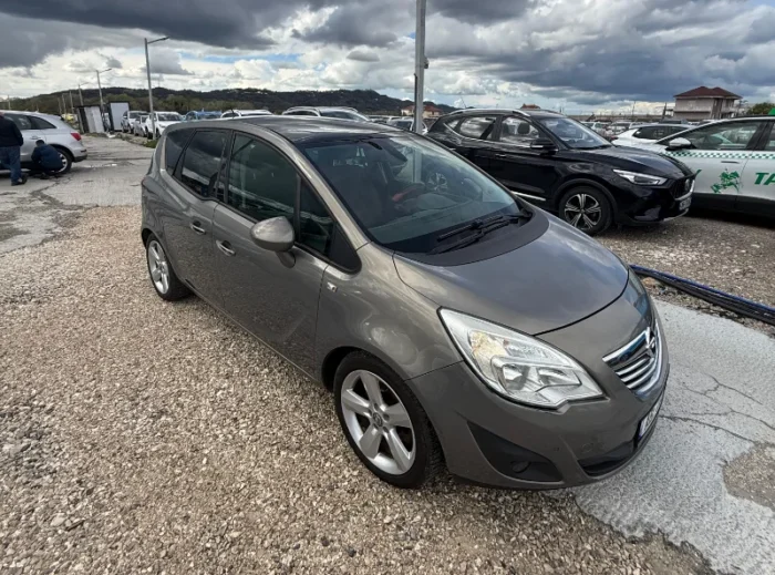 Grey Opel Meriva 2012 2.0 diesel manual compact MPV with panoramic sunroof and dark interior parked near Tirana International Airport Rinas