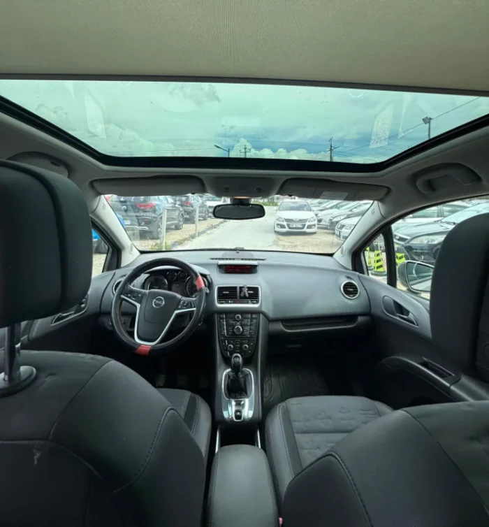 Grey Opel Meriva 2012 2.0 diesel manual compact MPV with panoramic sunroof and dark interior parked near Tirana International Airport Rinas