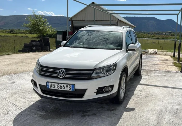 White Volkswagen Tiguan 2014 2.0 TDI diesel automatic 4x4 SUV parked in the Albanian countryside, available for rental from Tirana and Tirana Airport Rinas