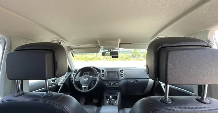 White Volkswagen Tiguan 2014 2.0 TDI diesel automatic 4x4 SUV parked in the Albanian countryside, available for rental from Tirana and Tirana Airport Rinas