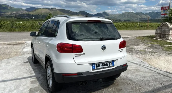 White Volkswagen Tiguan 2014 2.0 TDI diesel automatic 4x4 SUV parked in the Albanian countryside, available for rental from Tirana and Tirana Airport Rinas