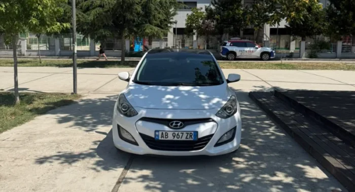 White Hyundai i30 2014 1.6 CRDi diesel automatic hatchback with full panoramic roof parked in Tirana, available for car rental in Albania with TiRental