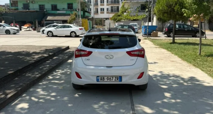 White Hyundai i30 2014 1.6 CRDi diesel automatic hatchback with full panoramic roof parked in Tirana, available for car rental in Albania with TiRental