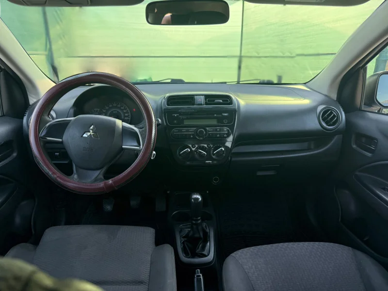 Mitsubishi Space Star 2017 - 1.0 Petrol Manual Hatchback Rental in Tirana Albania 32 - Car Rent in Albania White Mitsubishi Space Star 2017 1.0 petrol manual five‑door hatchback parked near Albanian mountains and Tirana Airport, available for car rental with TiRental