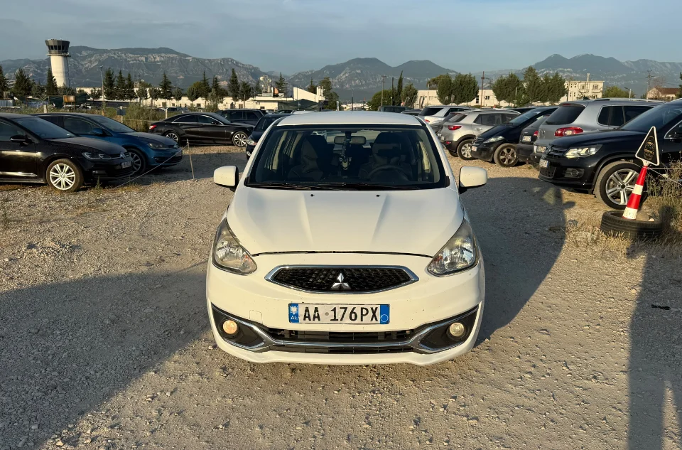 Mitsubishi Space Star 2017 - 1.0 Petrol Manual City Car Rental in Albania 16 - Car Rent in Albania White Mitsubishi Space Star 2017 1.0 petrol manual 5‑door hatchback parked near mountains and Tirana Airport, available for car rental in Albania with TiRental