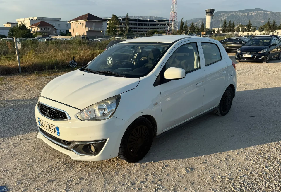 Mitsubishi Space Star 2017 - 1.0 Petrol Manual City Car Rental in Albania 15 - Car Rent in Albania White Mitsubishi Space Star 2017 1.0 petrol manual 5‑door hatchback parked near mountains and Tirana Airport, available for car rental in Albania with TiRental