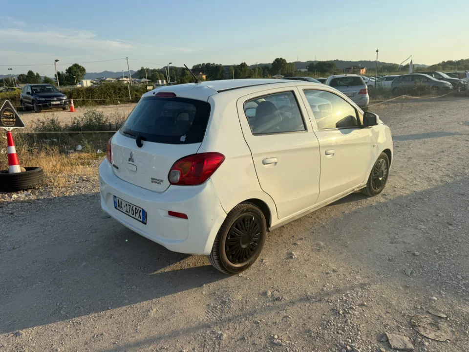 Mitsubishi Space Star 2017 - 1.0 Petrol Manual City Car Rental in Albania 17 - Car Rent in Albania White Mitsubishi Space Star 2017 1.0 petrol manual 5‑door hatchback parked near mountains and Tirana Airport, available for car rental in Albania with TiRental