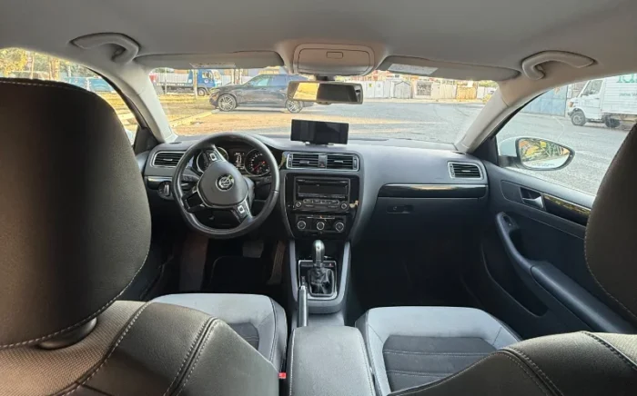 White Volkswagen Jetta 2015 2.0 TDI automatic diesel sedan parked in Tirana, available for car rental in Albania with TiRental