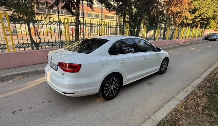 White Volkswagen Jetta 2015 2.0 TDI automatic diesel sedan parked in Tirana, available for car rental in Albania with TiRental